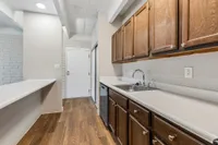 Charming kitchen with sleek wooden cabinets, modern countertops, and warm wood flooring, perfect for culinary adventures.