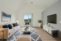 Bright and modern living room featuring vaulted ceilings and plank flooring!
