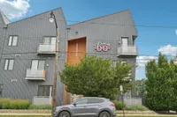 Contemporary apartment building with unique architectural design, featuring metal cladding and private balconies, offering a modern living experience.