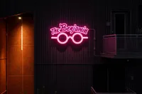 Chic urban aesthetic with neon sign reading 'The Benjamin' highlighting modern design.