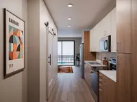 Modern apartment kitchen with sleek wood cabinetry, stainless steel appliances, and a stylish Bauhaus artwork.