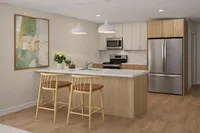 Contemporary kitchen with elegant wooden cabinetry, modern stainless steel appliances, a chic breakfast bar, and stylish pendant lighting.