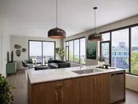 Modern open-concept kitchen and living room with sleek finishes, large windows offering city views, and stylish decor.