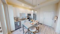 Chic modern kitchen with granite countertops, stainless steel appliances, and elegant pendant lighting, enhancing the open-concept layout.