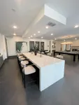 Elegant communal space with a stunning marble island, chic bar stools, and modern lighting, perfect for entertaining.