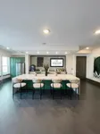 Elegant communal kitchen with modern green cabinetry, marble countertop island, and sleek bar stools at Soltair Cypress Creek.
