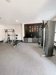 Modern communal gym with state-of-the-art equipment, sleek black wall accents, and abundant natural light.