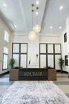 Elegant apartment lobby at Soltair with modern decor, stylish pendant lighting, and inviting reception area.