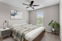 Cozy bedroom with a stylish bed, modern artwork, and a lush potted plant near the window.