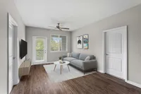 Stylish living room with a sleek gray sofa, wooden floor, and modern decor.