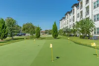 Experience luxury living with a private putting green surrounded by vibrant greenery.