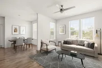 Chic living room with large windows, modern furnishings, and a cozy dining area.