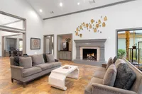 Inviting living room with plush gray sofas, elegant fireplace, and modern decor, perfect for relaxation and social gatherings.