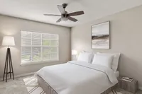 Bright and inviting bedroom featuring a cozy bed with crisp white linens, elegant ceiling fan, and modern floor lamp, creating a serene retreat.