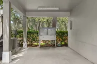 Covered outdoor area featuring a stainless steel wash station surrounded by lush greenery, offering a serene and functional space.