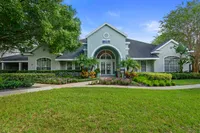 Elegant residential building with a charming archway entrance, lush landscaping, and a vibrant garden path.