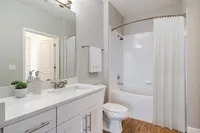 Renovated bathroom with sleek fixtures, elegant vanity, and a pristine bathtub.