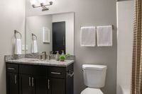 Elegant modern bathroom with sleek granite countertop, stylish fixtures, and soft lighting creating a serene atmosphere.