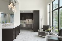 Chic clubhouse kitchen with sleek cabinetry, artistic lighting, and cozy seating area with large windows.