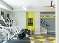 Modern fitness area with sleek treadmills, vibrant geometric flooring, and stylish decor, perfect for energizing workouts.