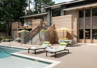 Luxurious outdoor pool area with stylish loungers, elegant seating, and a modern wood-paneled exterior.