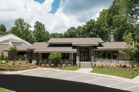 Charming single-story building with modern architecture and lush greenery, perfect for a tranquil lifestyle.