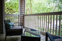 Charming outdoor patio with cozy seating, perfect for relaxing and enjoying lush green views.