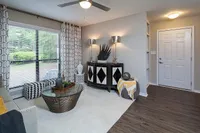 Chic living room with modern decor, featuring large window with geometric curtains, elegant sideboard, and stylish glass coffee table on plush rug.