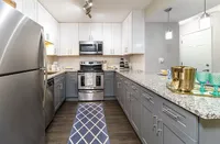 Modern kitchen with sleek stainless steel appliances, elegant granite countertops, and ample storage space in stylish cabinetry.