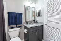 Chic bathroom with elegant granite countertop, modern fixtures, and plush navy towels, creating a serene oasis.