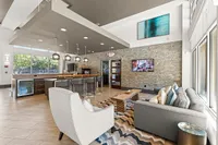 Modern and inviting communal lounge with chic decor, featuring a spacious seating area, stylish kitchen bar, and ambient lighting.