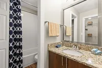 Chic bathroom featuring a granite countertop, modern fixtures, and a stylish navy patterned shower curtain.