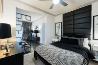 Modern bedroom featuring elegant black and white decor, stylish art, and a unique partition in a chic apartment setting.