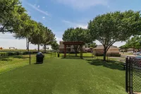 Inviting outdoor space with lush greenery, pergola, and fencing, perfect for relaxation or gatherings.
