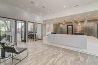 Elegant office reception area with modern design, featuring stylish seating, contemporary lighting, and private meeting rooms.