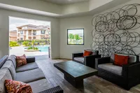 Elegant indoor lounge with stylish seating, modern decor, and a view of the inviting pool and garden area.