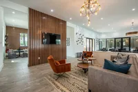 Modern living area with elegant lighting, cozy seating, and a sleek wall-mounted TV, ideal for relaxation and entertainment.