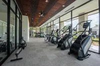Sleek and modern fitness center with state-of-the-art cardio equipment, offering a bright and spacious workout environment with large windows.