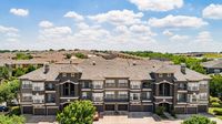 Elegant apartment complex nestled in a serene suburban neighborhood, featuring modern architecture with multiple balconies and lush greenery.