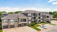 Elegant apartment complex with modern architecture, featuring spacious balconies and convenient parking, set against a scenic backdrop of lush greenery.