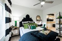 Elegant bedroom featuring a chic black and green color scheme, luxurious pillows, and an organized walk-in closet.