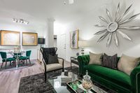 Luxurious living room with elegant green velvet sofa, modern decor, and ambient lighting creating a welcoming atmosphere.