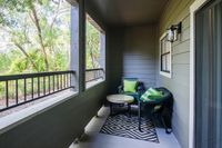 Charming patio with cozy seating area, surrounded by lush greenery, perfect for relaxation.