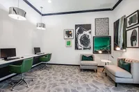 Chic modern office space with sleek workstations, artistic decor, and cozy seating, featuring vibrant green accent chairs and stylish lighting.