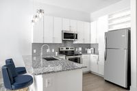 Modern kitchen with sleek stainless steel appliances, elegant granite countertops, and stylish pendant lighting, creating a bright and inviting space.