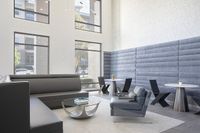 Modern and inviting lounge area with sleek furniture, high ceilings, and abundant natural light from large windows.