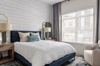 Bright and elegant bedroom with a plush bed, stylish decor, and large window for abundant natural light.