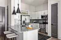 Modern kitchen with sleek granite countertops, stainless steel appliances, and chic pendant lighting, offering a stylish and functional space for culinary delights.
