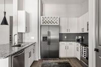 Modern kitchen with sleek stainless steel appliances, elegant granite countertops, and stylish cabinetry offering ample storage.