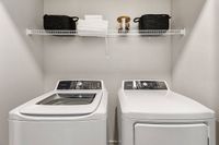 Modern laundry area with sleek washer and dryer, featuring organized shelving and stylish storage baskets.